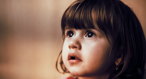 طفلة على يمين الصورة، وتنظر للأعلى.
